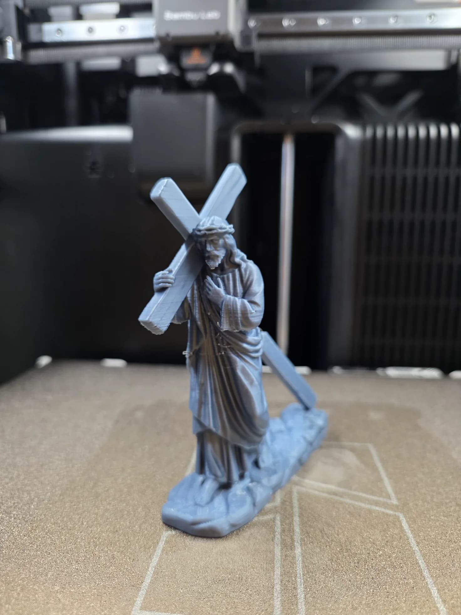 Estátua Cristo com a cruz vista frontal mostrando a túnica e a coroa de espinhos