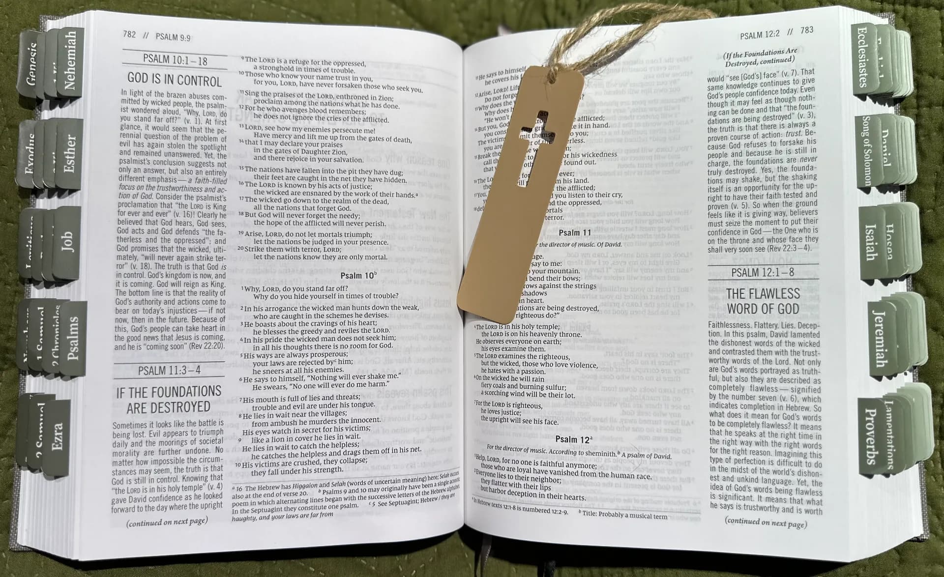 Marcador cruz vazada vista frontal sobre página de Bíblia
